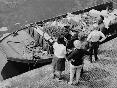 361192 Afbeelding van enkele omstanders bij een vuilnisschuit in de Oudegracht te Utrecht.
